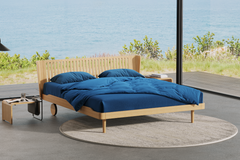 wooden Noa bed in a room with beach background