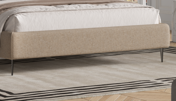 Beige upholstered bed frame with mattress on a wooden floor.