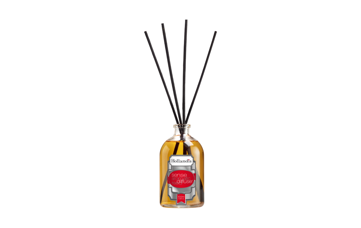 Reed diffuser with black sticks in a glass bottle on a white background
