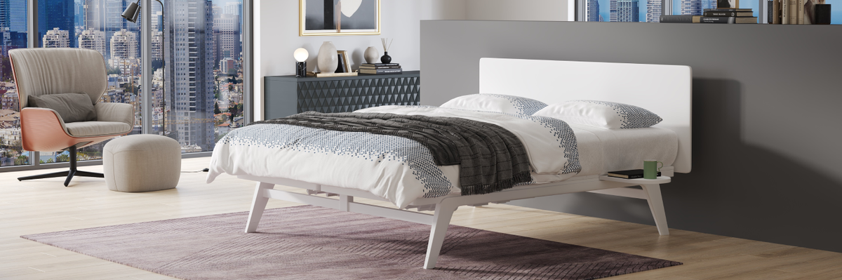 Modern bedroom with a cityscape view, bed, chair, and artwork.