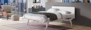 Modern bedroom with a bed, chair, and cityscape view