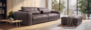 Gray sofa in a modern living room with large windows and decor.