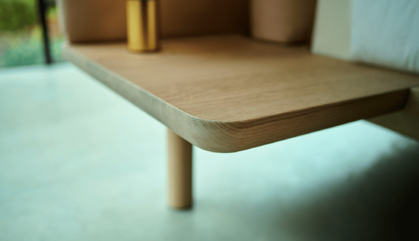 Wooden side table with a gold accent on a light background