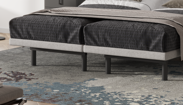 Bed with dark bedding on a patterned rug in a room setting